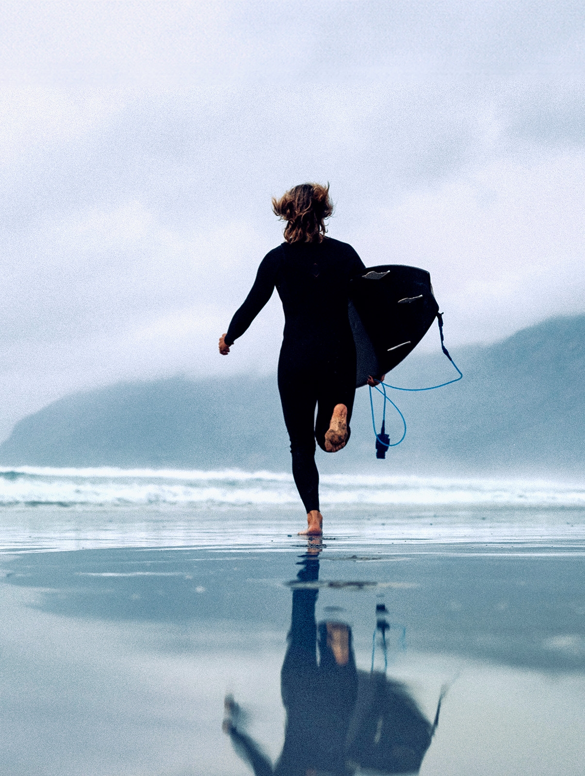 <p>Surfer woman running with surfboard in Lanzarote Canary Islands, Famara beach</p>
