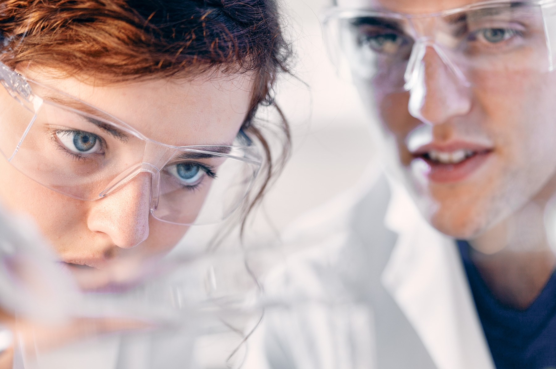 <p>Two chemistry laboratory researchers, a young man and a young woman working together in a biology, chemistry research laboratory.= in a university. Focus on the laboratory equipment with the personnel in the background. Photographed in horizontal format.</p>
